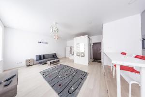 カウナスにあるSandra apartamentaiの白いリビングルーム(床に黒い敷物付)