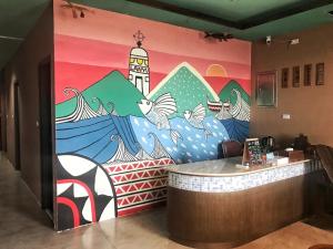 a wall with a mural of a building with birds at Two Fish Homestay in Lanyu