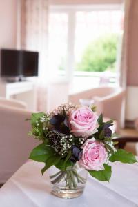 バート・メルゲントハイムにあるGästehaus Pfeifferのテーブルの上にピンクのバラが詰まった花瓶