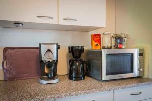 eine Küchentheke mit einer Mikrowelle und einer Kaffeemaschine in der Unterkunft Ferienwohnung Raina in Bad Säckingen