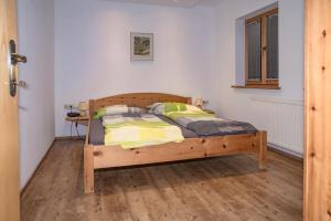 1 dormitorio con cama de madera en una habitación en Apartment Bachmaier, en Bramberg am Wildkogel