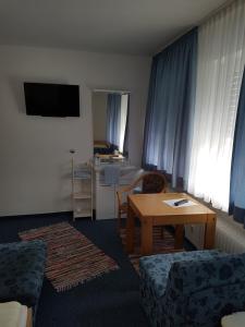 a living room with a table and a room with a kitchen at Hotel Giesing in Munich