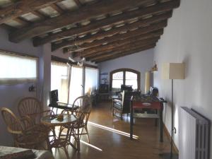 a living room with chairs and a table and a dining room at Cal Fuster De La Plaça in San Martín de Tous
