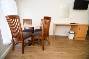 
a wooden table and chairs in a small room at Dandenong Motel in Dandenong
