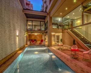 an indoor pool in a house with red chairs and stairs at Yaad City Hotel in Marrakesh