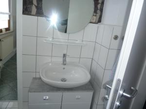 a bathroom with a sink and a mirror at im gelben Haus in Trusen