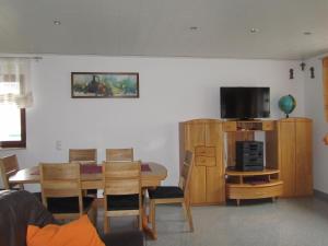 a living room with a dining room table and a television at Ferienhaus Wunsch in Oberkirch