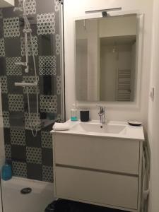 y baño con lavabo y ducha con espejo. en Appartement Design IV - Port du Rosmeur - Douarnenez en Douarnenez