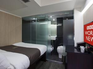 a bedroom with a bed and a shower and a toilet at The Z Hotel Soho in London