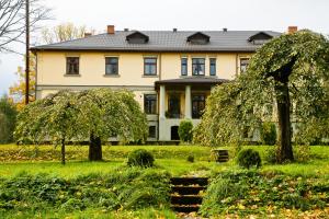 a large house with trees in front of it at Hotel Grasu Pils in Cesvaine