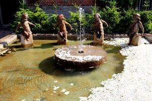 a fountain with statues of children in a pond at B&B Hof te Spieringen in Vollezele