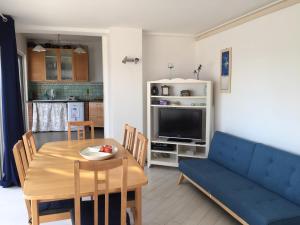 salon ze stołem i niebieską kanapą w obiekcie Villa Asia Holiday Home w mieście SantʼAgata sui Due Golfi