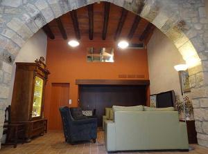 a living room with a couch and a fireplace at Cal Fuster De La Plaça in San Martín de Tous