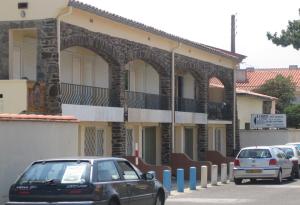 un coche aparcado frente a un edificio en Locations Meublées Plage des Pins en Argelès-sur-Mer