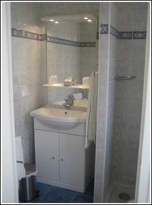y baño con lavabo y ducha con espejo. en Locations Meublées Plage des Pins en Argelès-sur-Mer