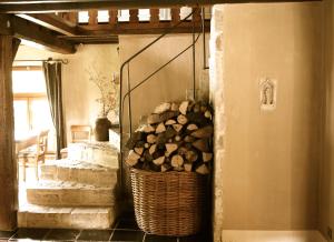 una cesta llena de troncos en una habitación con escaleras en B&B Hof te Spieringen en Vollezele