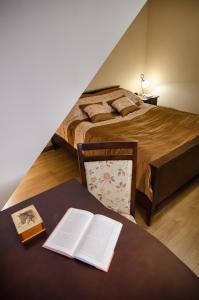 a bedroom with a bed and a table with an open book at Pensjonat Enklawa in Trzebnica