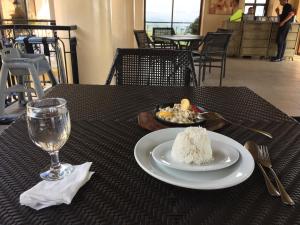 a table with a plate of rice and a glass of water at Cityland Jane's Apartment in Tagaytay