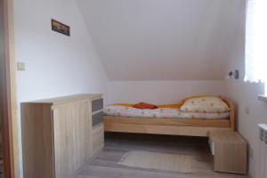 レスコにあるAgroturystyka Domek u Barbaryの小さなベッドルーム(ベッド1台、キャビネット付)