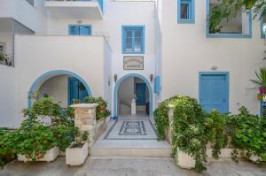 un edificio blanco con puertas y plantas azules en Mike's Studios en Naxos
