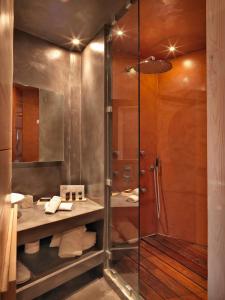 a glass shower in a bathroom with a sink and a shower at Kipi Suites in Kipoi