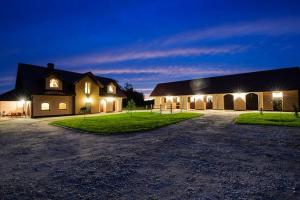 a large building with lights on in front of it at Pensjonat Enklawa in Trzebnica +14 photos