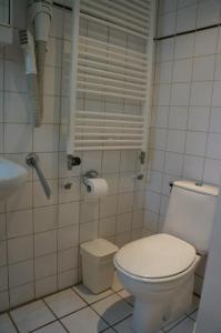 Baño blanco con aseo y lavamanos en Bungalow Callantsoog, en 't Zand