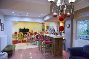 a kitchen and dining room with a bar with pink chairs at Oscar Hotel in Amfilochia
