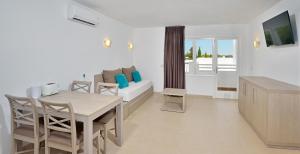 a living room with a table and a couch at Sol Cala d´Or Apartamentos in Cala d´Or