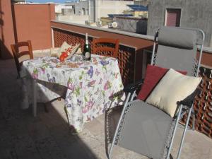 a table and chairs on a balcony with a bottle of wine at VALDERICE VACANZE biker's friend in Valderice