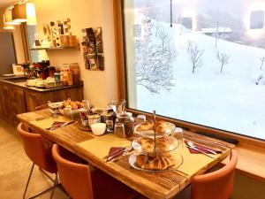 a table with bread and other food on it at B&B Le jardin de Pierre in Nus