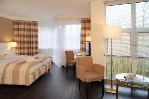 1 dormitorio con 1 cama, 1 mesa y 1 silla en relexa Waldhotel Schatten Stuttgart en Stuttgart