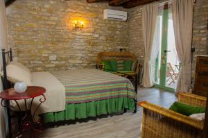a bedroom with a bed and a brick wall at Le Voltarelle Bed & Breakfast in Serra San Quirico