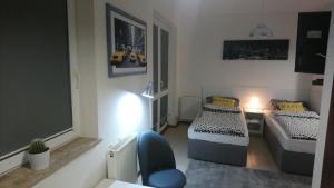 a small room with two beds and a couch at Apartament Kniaziewicza - Komfortowe Noclegi in Piaseczno