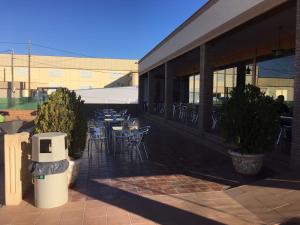 a patio with tables and chairs and a building at Hostal Venta del Peral in Cúllar de Baza