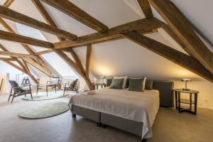 a bedroom with a bed in a room with wooden ceilings at Obelisque in Bruges