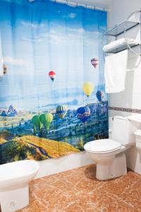 a bathroom with a toilet and a shower curtain with hot air balloons at Apartamento Centro in Granada