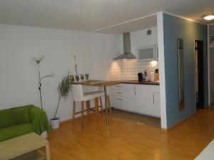 una cucina e un soggiorno con tavolo e divano di Cityappartment am Stadttheater a Friburgo in Brisgovia