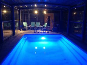 a swimming pool at night with a table and chairs at B&B Agnes in Vlissegem