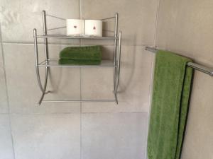 - Baño con 2 toallas y 1 toalla verde en Impala Chalets en Phalaborwa