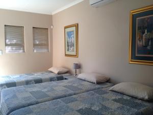 a room with two beds in a room at Impala Chalets in Phalaborwa