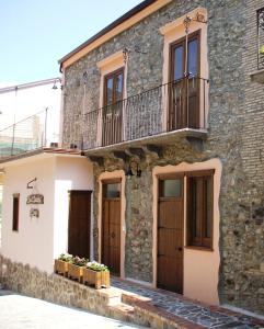 een stenen huis met twee balkons op een gebouw bij Affittacamere Il Borgo in Francavilla Marittima