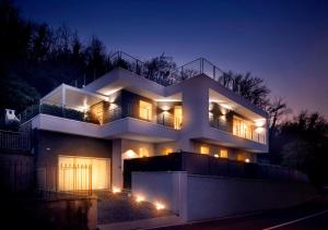 una grande casa bianca di notte con luci di B&B Le Farfalle a San Felice del Benaco