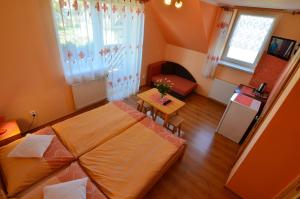 a room with two beds and a table in it at Penzión Family Rušin in Veľká Lomnica