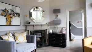a living room filled with furniture and a mirror at The Lawn Guest House Gatwick in Horley