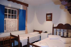 um quarto com duas camas e uma janela em Pousada Solar da Inconfidencia - By UP Hotel - fácil acesso a Praça Tiradentes em Ouro Preto
