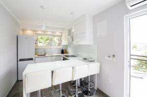 a white kitchen with white appliances and a window at Mare in Rogoznica