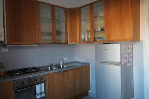 a kitchen with wooden cabinets and a white refrigerator at Interno24 Apartment in La Spezia
