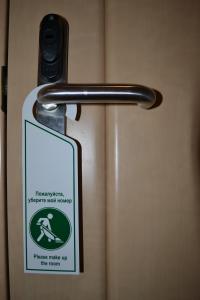 a sign is attached to a door with a metal handle at Nevskaya Classika in Saint Petersburg