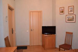 a room with a television and a desk with a chair at Nevskaya Classika in Saint Petersburg